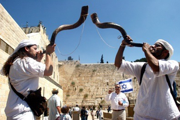A Jewish man blows the Shofra at the Western Wall in the Old City of Jerusalem